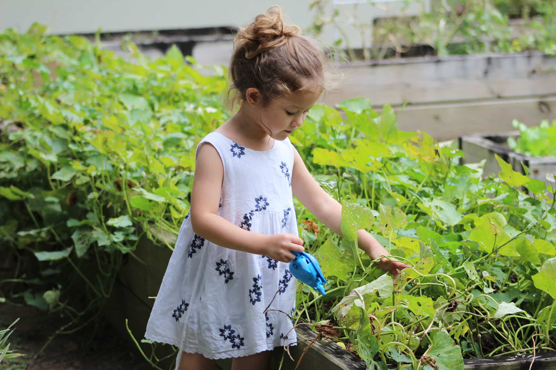 young girl plays in a garden