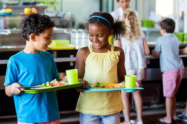 young students pick up their lunch in a school cafeteria