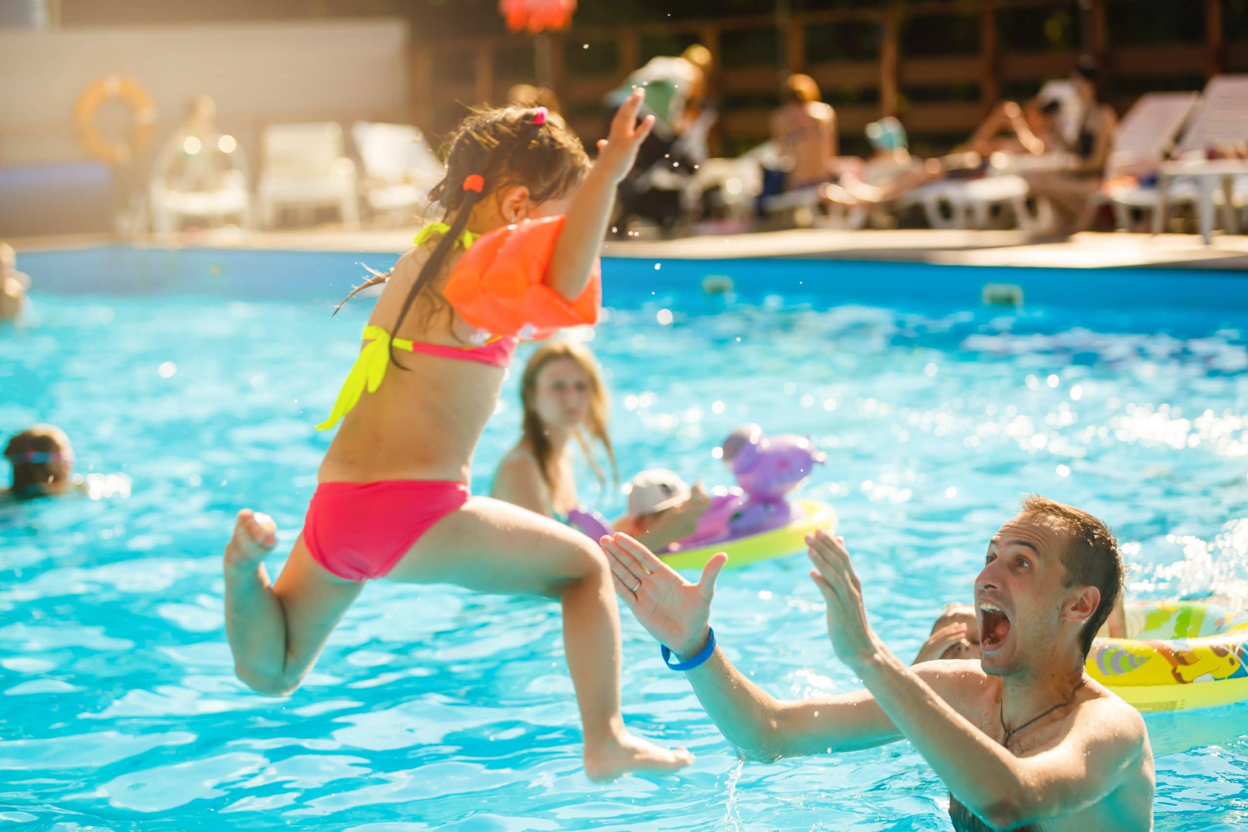 child jumping into pool