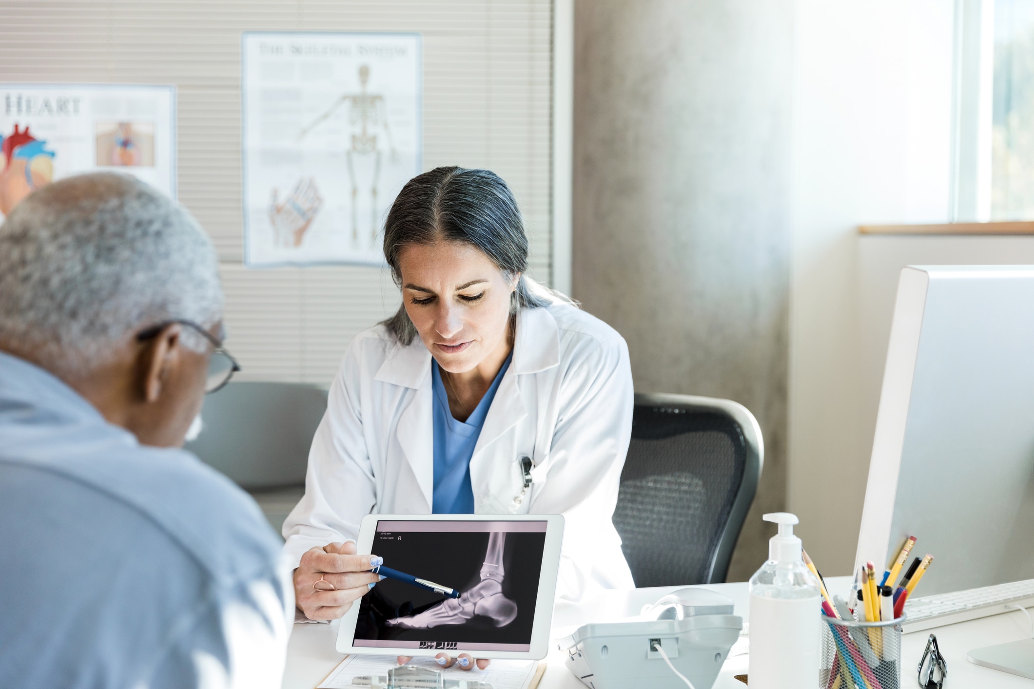 female doctor showing a patient an x-ray during foot pain treatment
