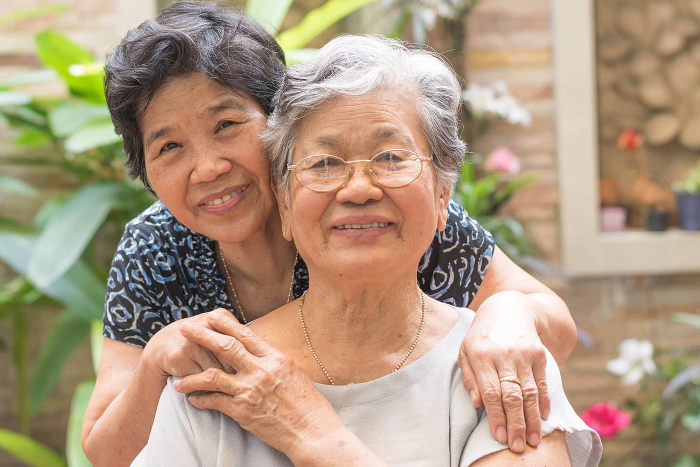 Two women embracing, smiling at camera