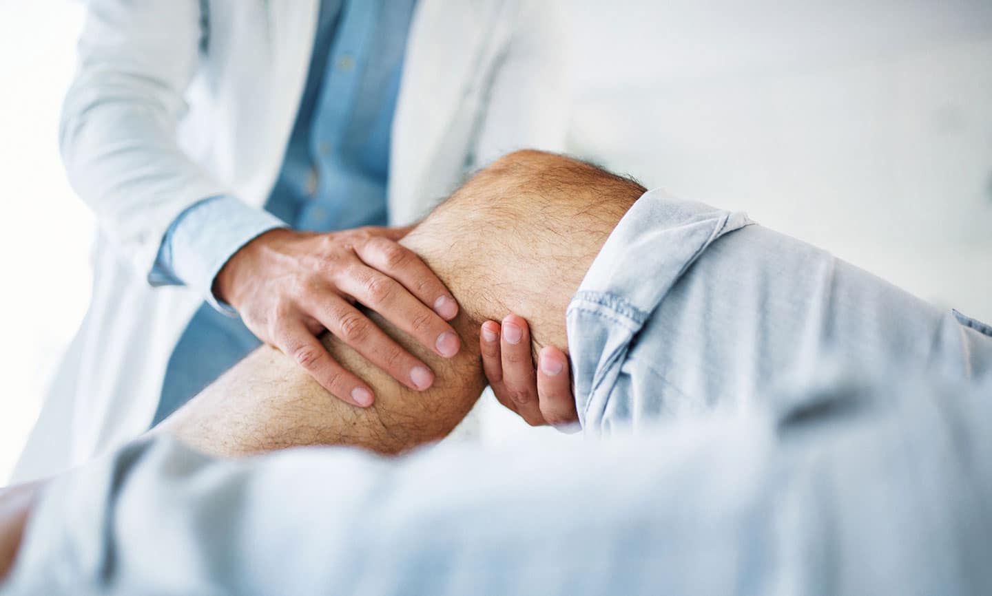 Doctor examining patient's knee